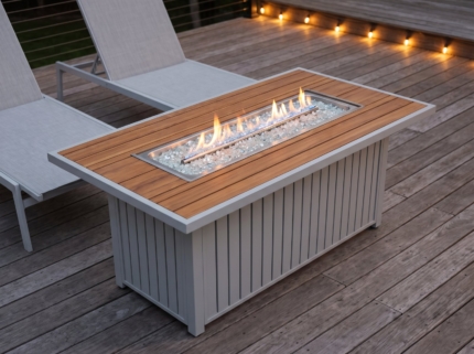 52 in. rectangular propane fire pit table with a low flame on a wooden deck