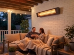 Infrared heater mounted above an outdoor sofa in the evening