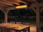 Slim carbon grey patio heater on a painted brick wall